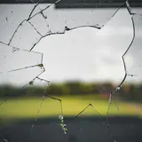 Een gebarsten ruit, met een veld erachter