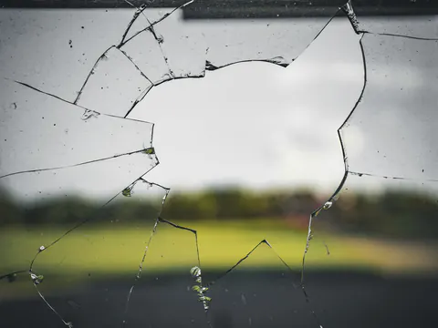 Een gebarsten ruit, met een veld erachter