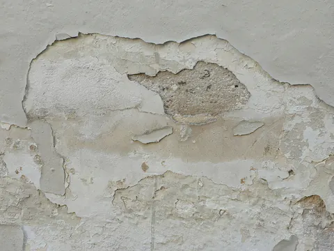 Pleister en verf die loskomen van een muur