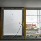 Een nieuw raam nog in de beschermfolie, met een stelling buiten