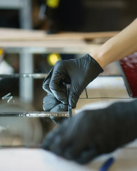 Handen in zwarte werkhandschoenen aan het werk op een tafel