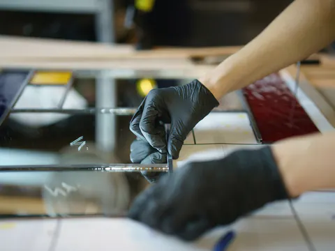 Handen in zwarte werkhandschoenen aan het werk op een tafel