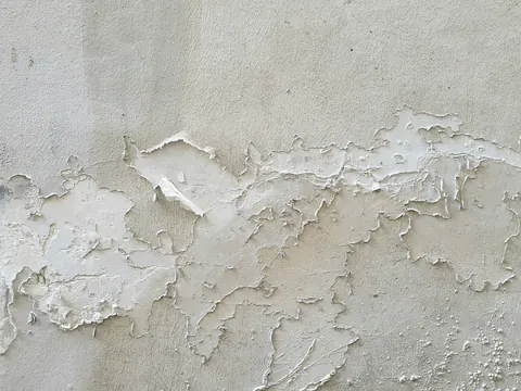 Afbladderende witte verf op een muur