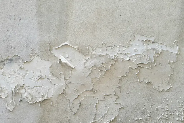 Afbladderende witte verf op een muur
